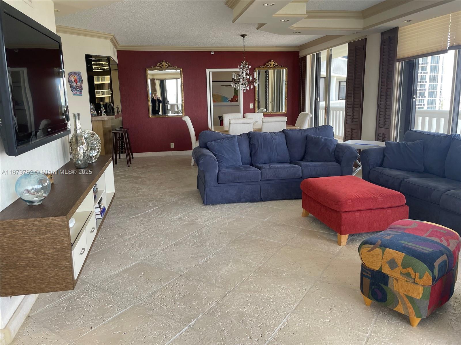 3000 Island Boulevard, Unit 2405 Aventura, FL 33160 - Photo 3 of 26 a living room with furniture a flat screen tv and large windows