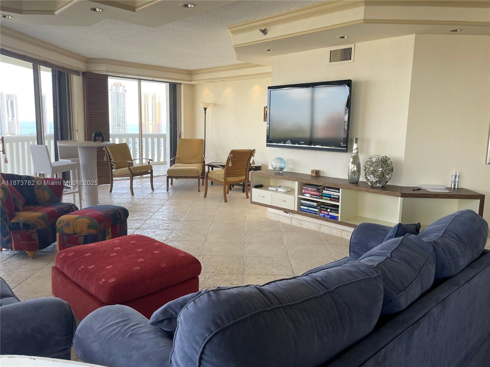 3000 Island Boulevard, Unit 2405 Aventura, FL 33160 - Photo 5 of 26 a living room with furniture and a flat screen tv