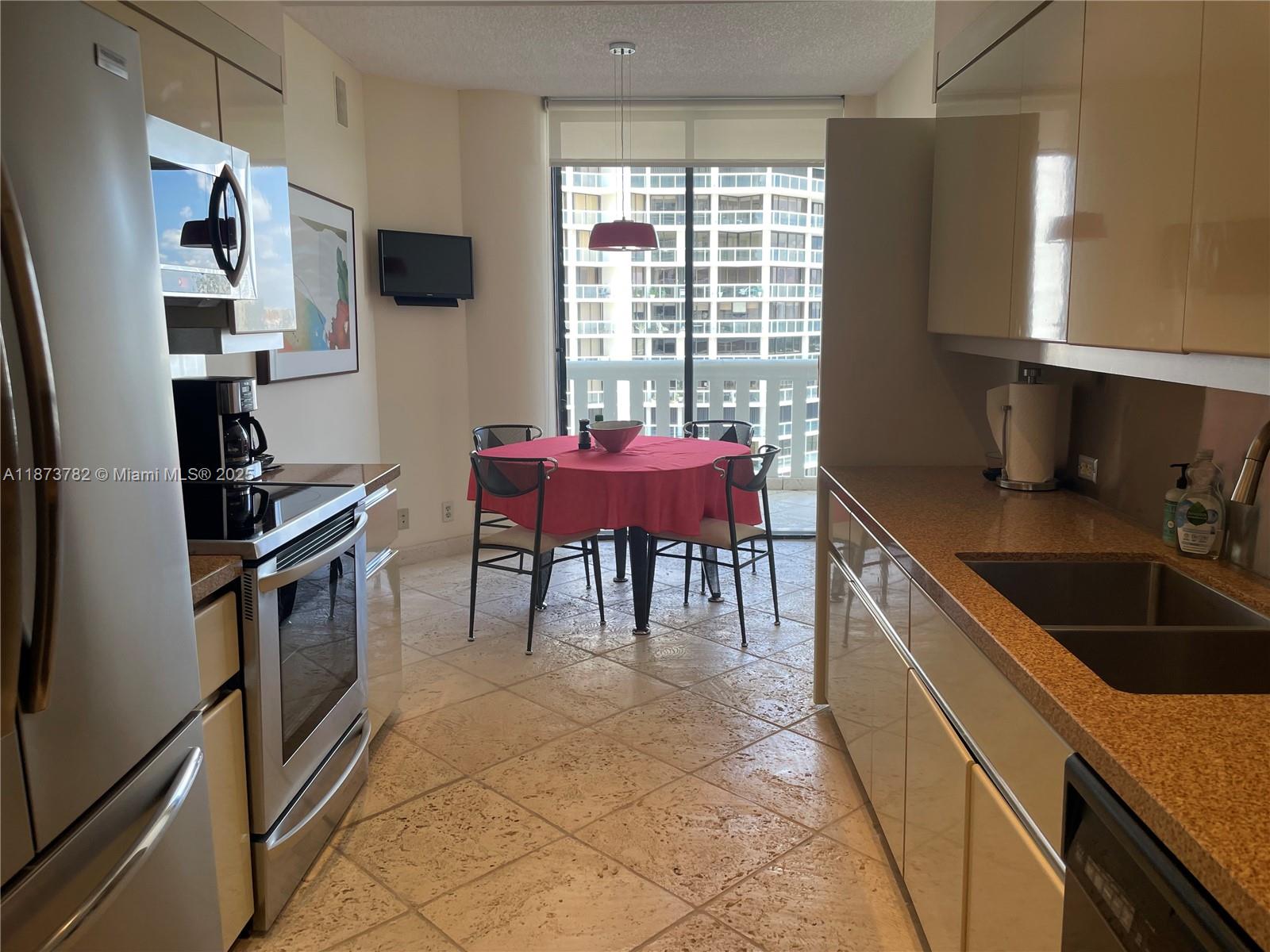 3000 Island Boulevard, Unit 2405 Aventura, FL 33160 - Photo 8 of 26 a kitchen with granite countertop a sink cabinets and appliances