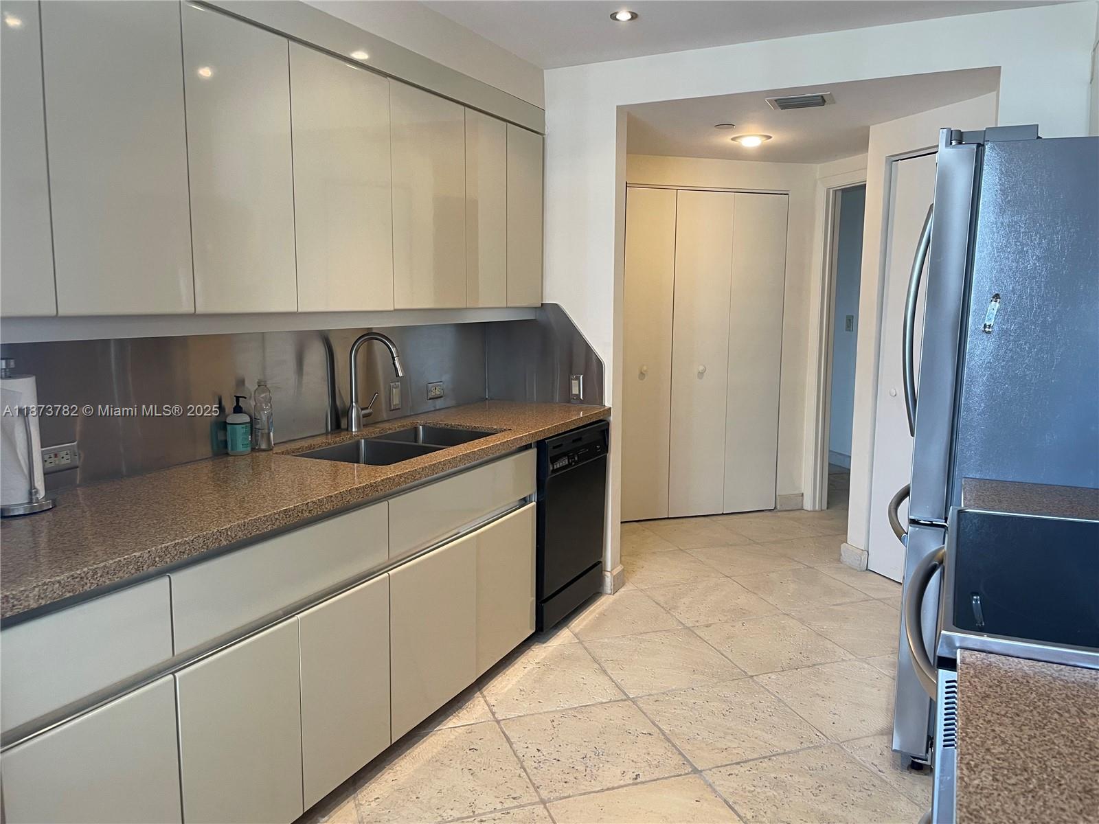 3000 Island Boulevard, Unit 2405 Aventura, FL 33160 - Photo 9 of 26 a kitchen with stainless steel appliances granite countertop a refrigerator and a sink