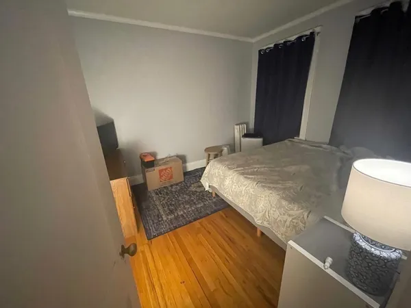 a bedroom with a bed and wooden floor