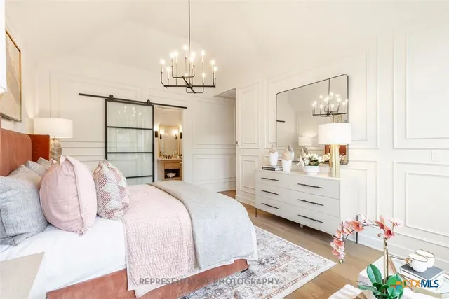 a bedroom with a bed and a chandelier