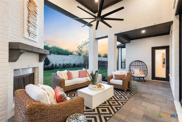 a living room with furniture a fireplace and a floor to ceiling window