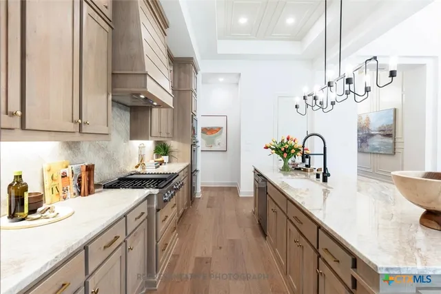 a kitchen with stainless steel appliances granite countertop a sink stove and refrigerator