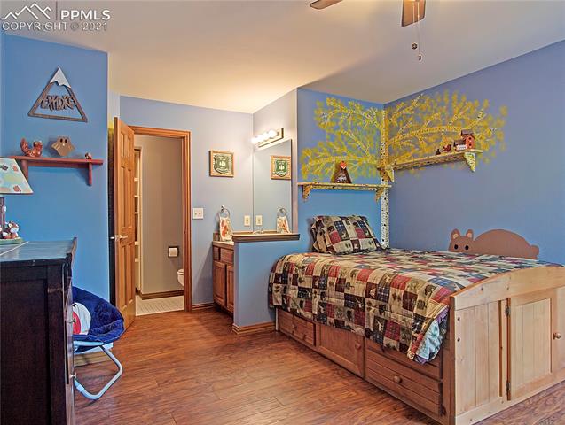 735 Winding Hills Road Monument, CO 80132 - Photo 28 of 42 Bedroom #3 has laminate floors, ceiling fan, walk-in closet and own sink vanity.