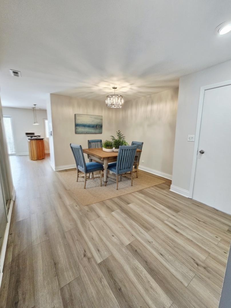 1550 Sandpebble Drive, Unit 210 Wheeling, IL 60090 - Photo 11 of 22 a view of a dining room with furniture and chandelier