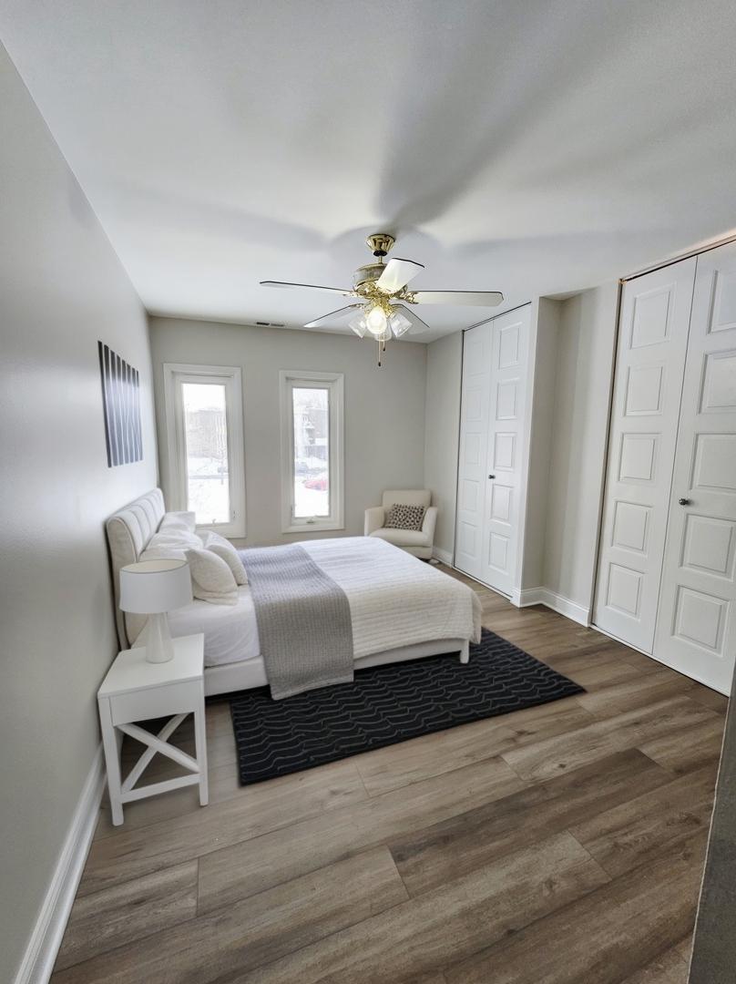 1550 Sandpebble Drive, Unit 210 Wheeling, IL 60090 - Photo 15 of 22 a spacious bedroom with a bed and a chandelier