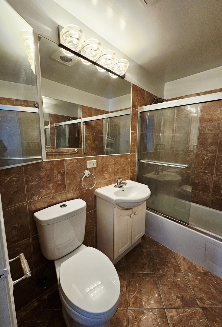 1550 Sandpebble Drive, Unit 210 Wheeling, IL 60090 - Photo 21 of 22 a bathroom with a toilet a sink and bathtub