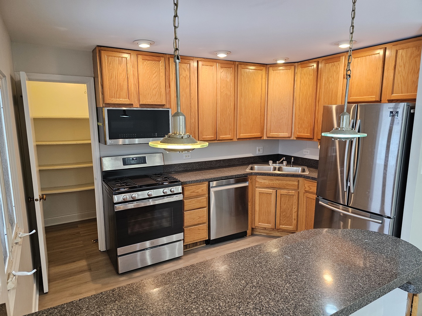 1550 Sandpebble Drive, Unit 210 Wheeling, IL 60090 - Photo 3 of 22 a kitchen with stainless steel appliances a stove sink and microwave