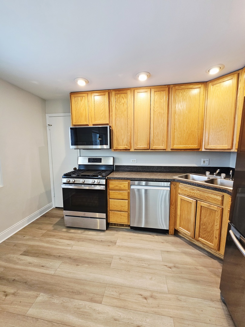 1550 Sandpebble Drive, Unit 210 Wheeling, IL 60090 - Photo 8 of 22 a kitchen with stainless steel appliances a stove and a microwave