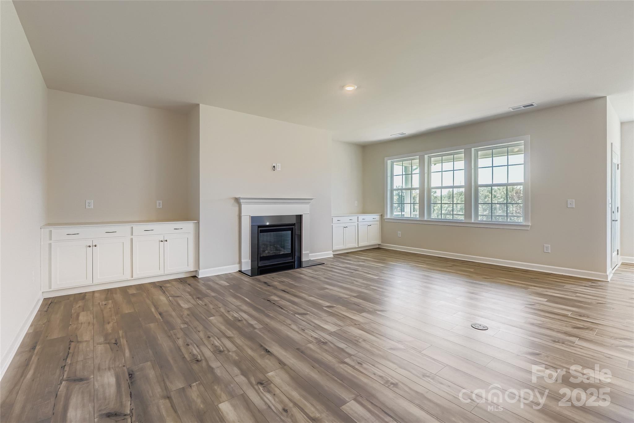 2267 Moon Crst Road Lancaster, SC 29720 - Photo 3 of 17 an empty room with wooden floor fireplace and windows
