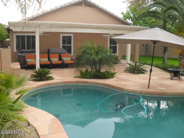 a swimming pool with outdoor seating yard and plants