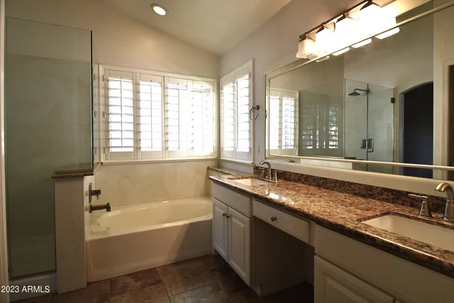 a bathroom with a granite countertop bathtub and a sink