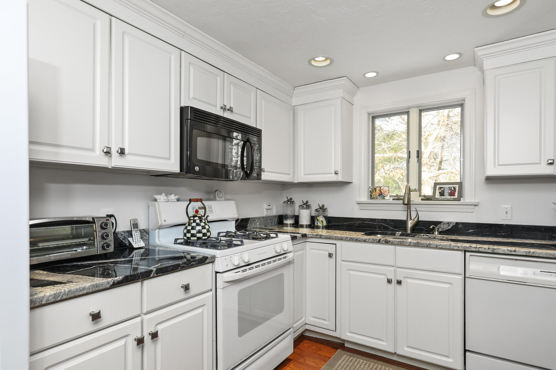21 Portside Drive Mashpee, MA 02649 - Photo 5 of 20 a kitchen with granite countertop white cabinets sink and stainless steel appliances