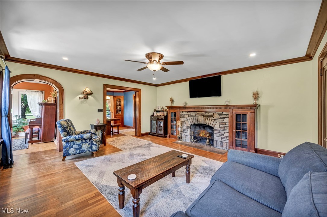 7550 Mayfield Road Chesterland, OH 44026 - Photo 13 of 45 Living room with a fireplace, ornamental molding, light wood finished floors, a ceiling fan, and recessed lighting