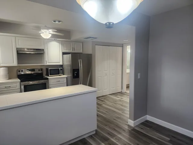 a large kitchen with cabinets and stainless steel appliances