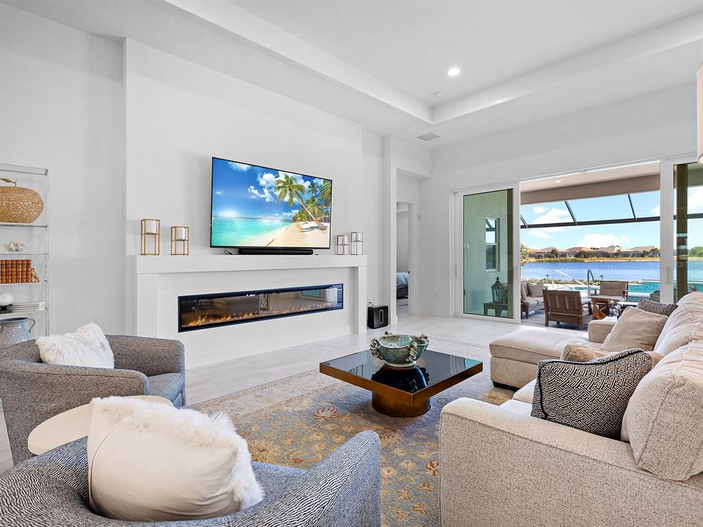 8043 Waterbend Trail Sarasota, FL 34240 - Photo 12 of 83 a living room with furniture a fireplace and a large window