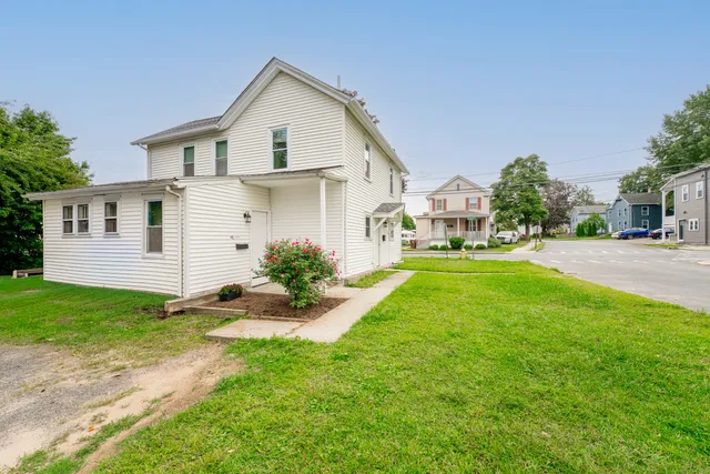 a front view of a house with a yard and trees