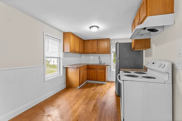 a kitchen with a stove a sink dishwasher and a refrigerator