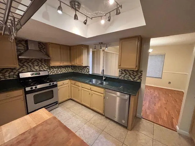 a kitchen with stainless steel appliances granite countertop a sink and a stove