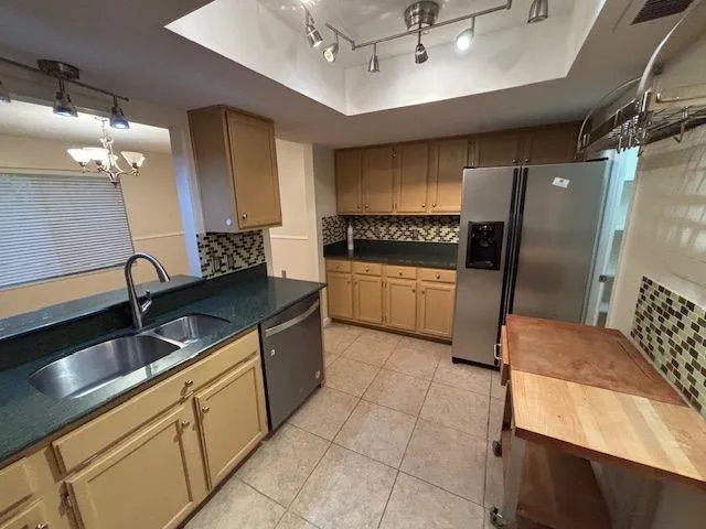 a kitchen with stainless steel appliances granite countertop a sink and a refrigerator