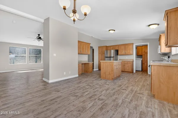 a room with wooden floors and kitchen view