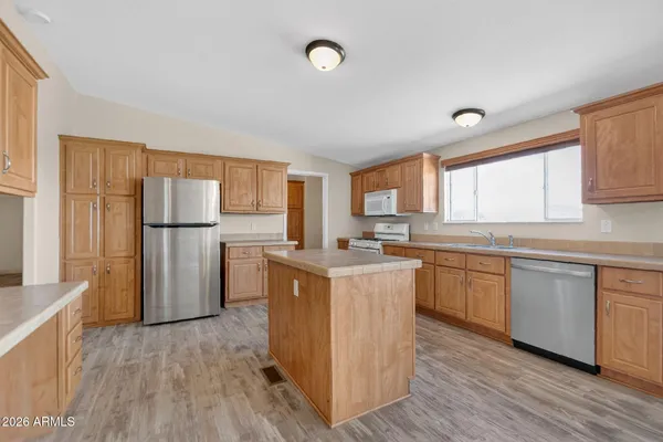 a kitchen with a refrigerator a sink dishwasher with a dining table and chairs