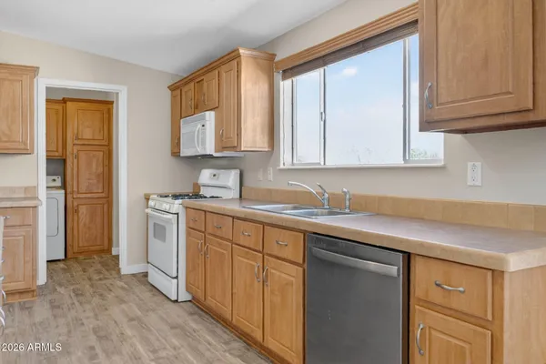 a kitchen with granite countertop white cabinets sink and stainless steel appliances