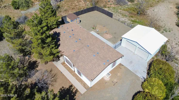 an aerial view of a house with a yard and large trees