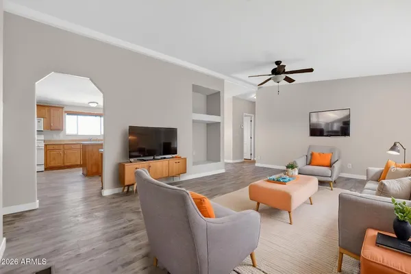 a living room with furniture kitchen view and a flat screen tv