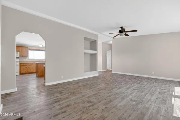 a view of a livingroom with wooden floor and a ceiling fan