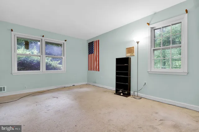 an empty room with windows and closet
