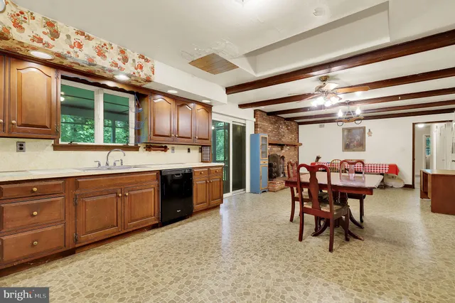 a kitchen with stainless steel appliances kitchen island granite countertop a table chairs in it and wooden floors