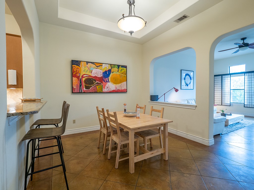 3609 Clawson Road, Unit B Austin, TX 78704 - Photo 10 of 28 Dining area featuring a coffered ceiling with a semi-flush mount fixture, tile flooring, and arched wall openings