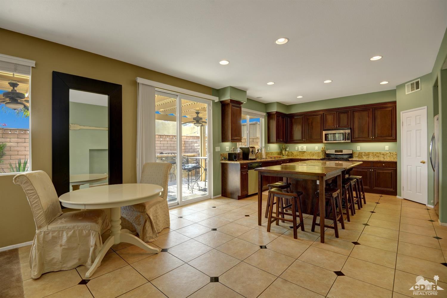37458 Blackburn Road Indio, CA 92203 - Photo 8 of 33 a kitchen with a dining table chairs and white appliances