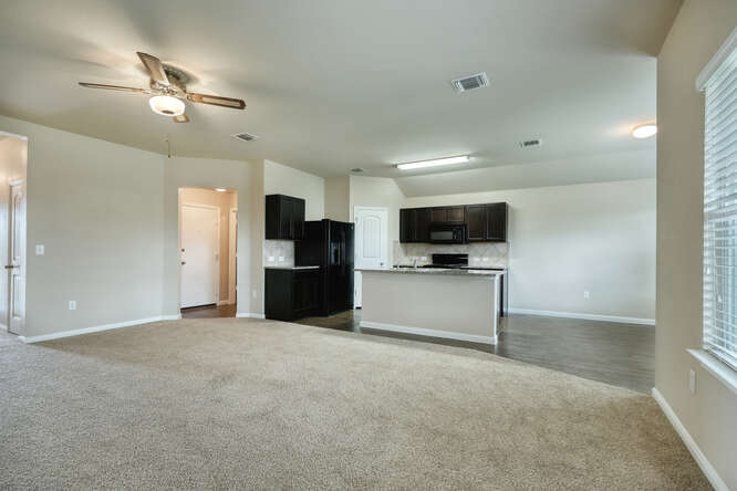 232 Voss Kyle, TX 78640 - Photo 3 of 15 Open-concept living area featuring a ceiling fan, carpet flooring, and neutral wall tones