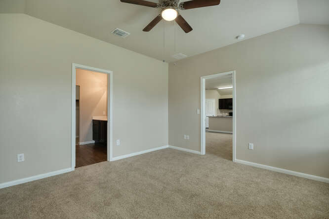 232 Voss Kyle, TX 78640 - Photo 8 of 15 Room featuring vaulted ceilings with a ceiling fan, neutral carpeting, and light-toned walls