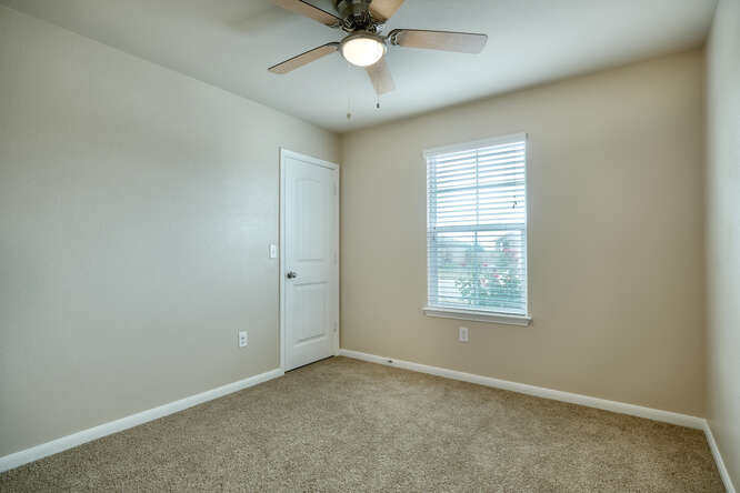 232 Voss Kyle, TX 78640 - Photo 10 of 15 Carpeted room with a ceiling fan light fixture, neutral wall color, white trim, and a window with blinds