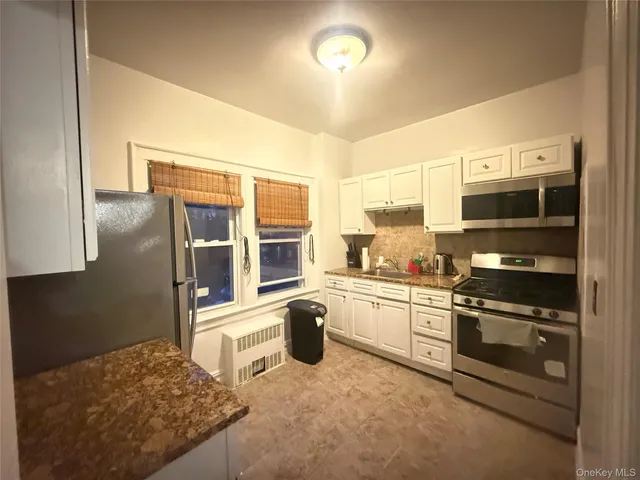 a kitchen with stainless steel appliances granite countertop a stove and a refrigerator