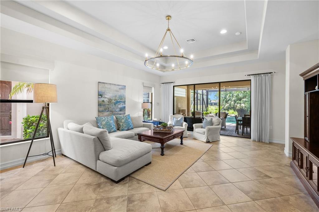 Living area featuring recessed lighting, a chandelier, light tile patterned floors, and a raised ceiling