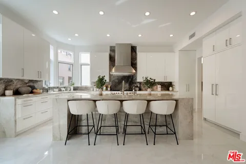 a kitchen with a sink and chairs