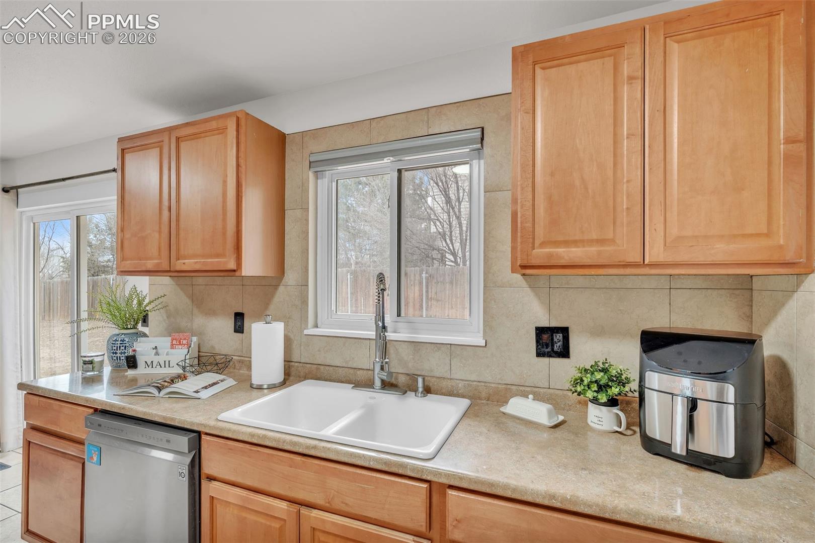 1498 Peterson Road Colorado Springs, CO 80915 - Photo 20 of 44 Kitchen featuring dishwasher, light countertops, and plenty of natural light