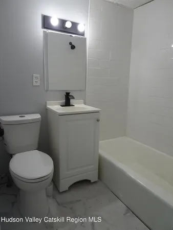 a white toilet sitting next to a bath tub