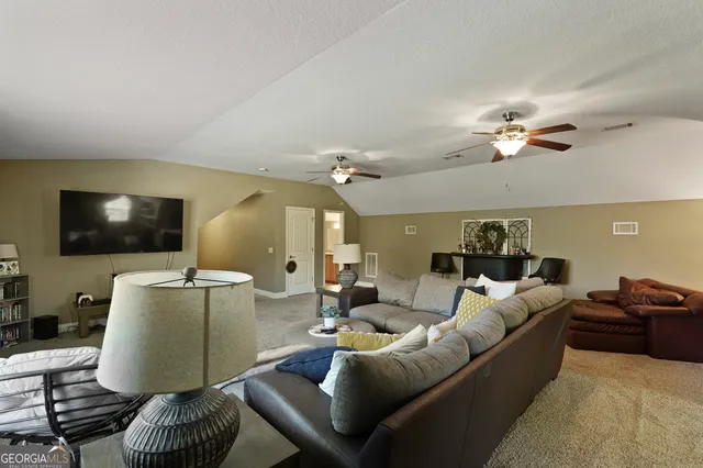 an aerial view of a house with a yard and trees all around