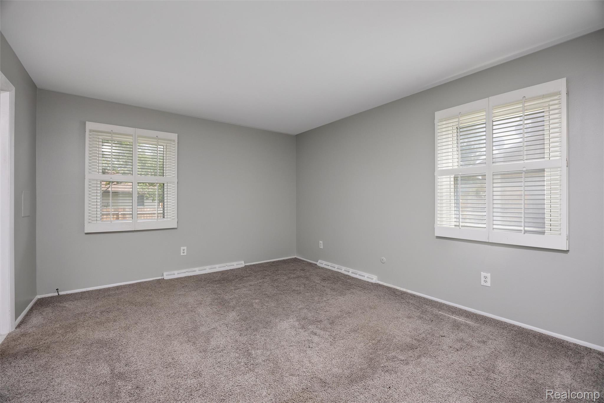 4942 Butler Drive Troy, MI 48085 - Photo 13 of 33 Room featuring two windows with white blinds, gray wall paint, and gray carpet flooring