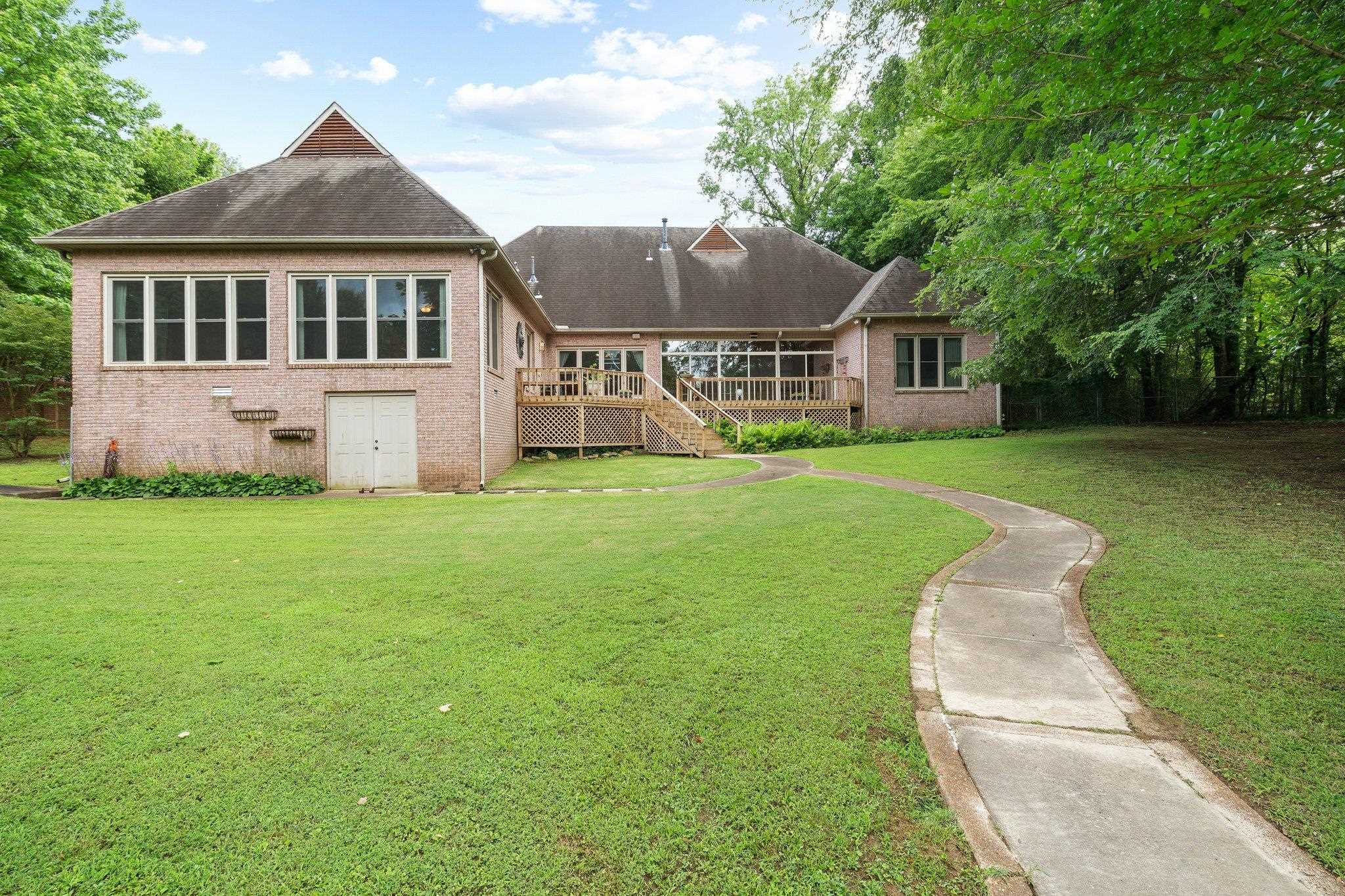6500 State Line Road Memphis, TN 38141 - Photo 24 of 40 Rear view of house featuring brick siding, a wooden deck, a lawn, and stairs