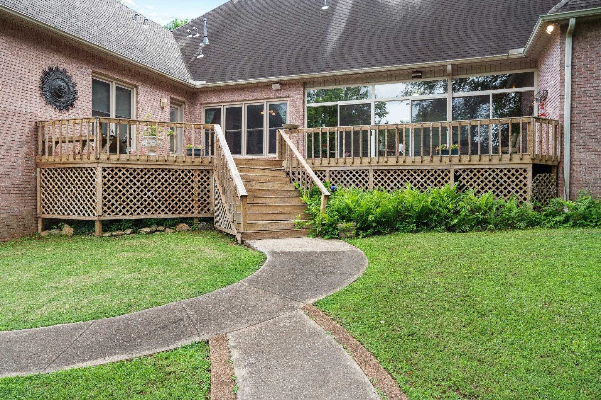 6500 State Line Road Memphis, TN 38141 - Photo 25 of 40 Rear view of property with a shingled roof, brick siding, a deck, a yard, and stairway