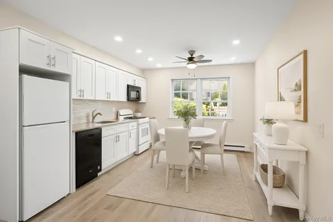 a kitchen with a white cabinets and wooden floor