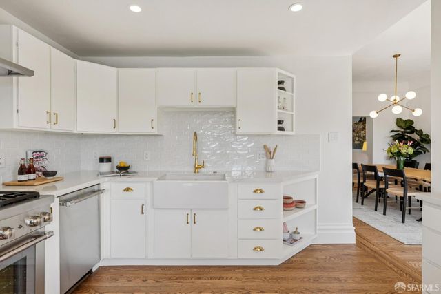 a kitchen with cabinets and wooden floor