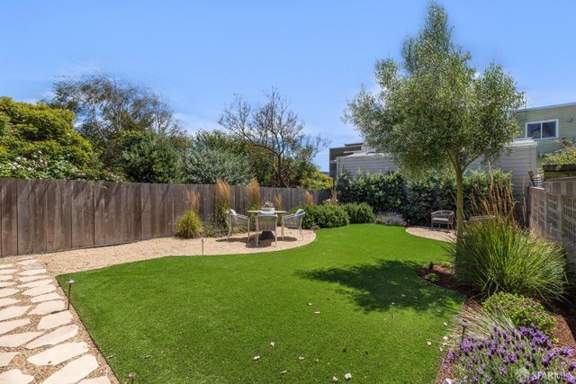 a view of a backyard with sitting area and garden